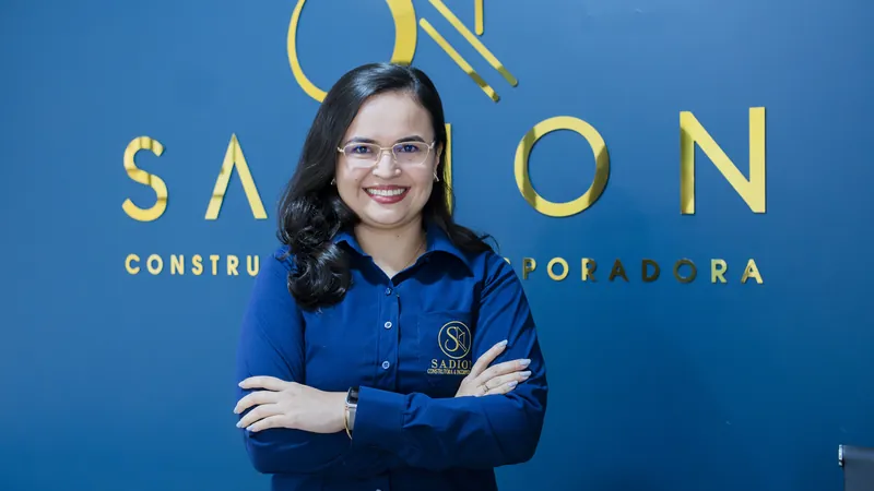 Consultora da Sadion sorrindo em frente ao logotipo da empresa